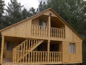 una grande casa in legno con un ampio ponte di Guest House Mirgvela a Omalo