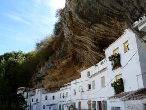 a group of buildings in front of a mountain at Casa cueva de la sombra in Setenil +15 photos