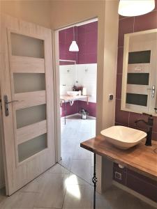 łazienka z drzwiami i umywalką w pokoju w obiekcie Pokoje Gościnne w mieście Przemyśl