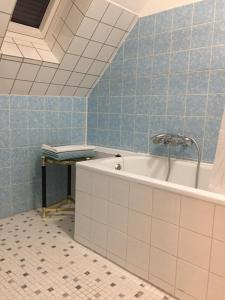 eine Badewanne im Bad mit blauen Fliesen in der Unterkunft LORENZ Apartment 2 in Hattingen