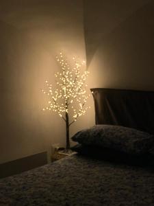 サレルノにあるTana del Papaのベッド横の壁に灯る木