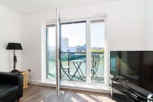 a living room with a flat screen tv and a balcony at Bramante Heights in Newport