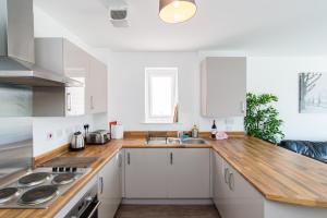 uma cozinha com armários brancos e um balcão de madeira em Bramante Heights em Newport