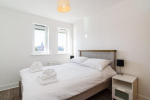 um quarto com uma cama branca e toalhas em Bramante Heights em Newport