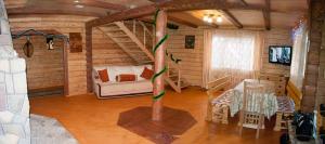 Sala de estar de una cabaña de madera con sofá en У Гриніва, en Polyanitsa Popovichovska