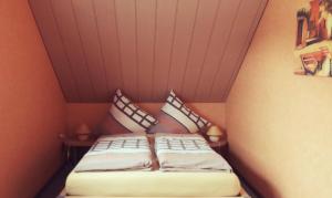 a bed in a small room with two pillows at Ferienhaus Rothaargebirge in Bad Berleburg