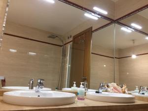 une salle de bain avec deux lavabos et un grand miroir dans l'établissement Sevilla Aljarafe Room, à Bormujos 14 autres photos