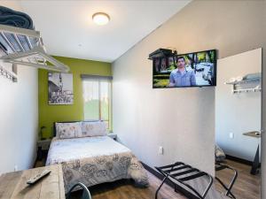 1 dormitorio con 1 cama y TV en la pared en HI Los Angeles - Santa Monica Hostel, en Los Ángeles