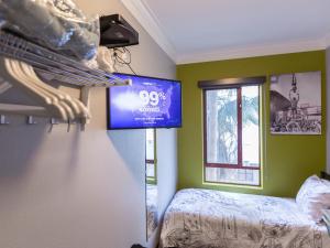 a bedroom with a bed and a tv on the wall at HI Los Angeles - Santa Monica Hostel in Los Angeles