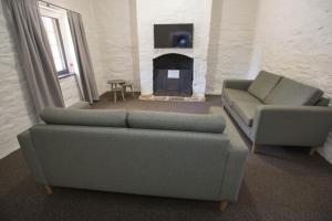 a living room with two couches and a fireplace at Paxton Square Cottages in Burra