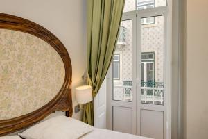 - une chambre avec un lit et une fenêtre dans l'établissement Graça Terrace, à Lisbonne