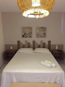 1 dormitorio con 1 cama y 2 toallas blancas en Pousada Portal da Ilha en Itarema