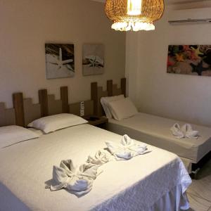 1 dormitorio con 2 camas y toallas blancas. en Pousada Portal da Ilha en Itarema