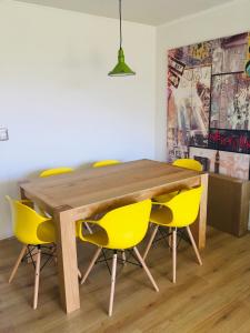 a dining room with a wooden table and yellow chairs at Lomas de Papudo 3, Bosque y Playa in Papudo