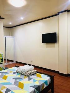 a room with a bed and a flat screen tv at Hadassah’s Place in Olango Island