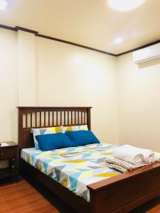 a bedroom with a bed with blue and yellow pillows at Hadassah’s Place in Olango Island