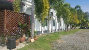 eine Straße mit Palmen und einem weißen Gebäude in der Unterkunft HOTEL SHAFURA 1 in Cukai