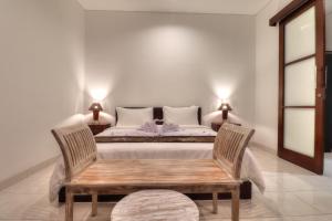 1 dormitorio con 1 cama con banco y 2 lámparas en Clover Villa Sanur, en Sanur