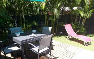a patio with a table and chairs and an umbrella at ChEZ MAYAH in Le Gosier