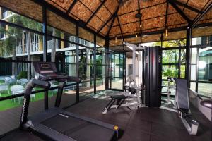 einem Fitnessraum mit Laufband und Trainingsgeräten in einem Gebäude in der Unterkunft NAP KRABI HOTEL - SHA Extra Plus in Krabi