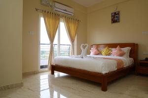 a bedroom with a bed and a large window at Lali Petals in Madikeri