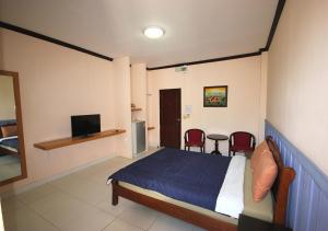 a bedroom with a bed and a television in it at Matini Amata in Ban Hua Phai