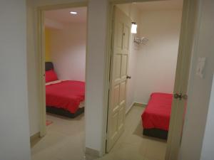 a bedroom with a bed with red sheets and a mirror at Famosa 2 Stay in Malacca