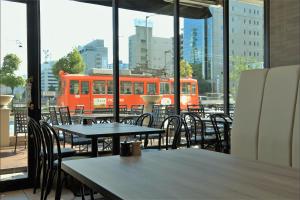 an orange bus on a city street with tables and chairs at HOTEL MYSTAYS Matsuyama in Matsuyama +76 photos