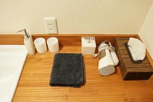 una cama con zapatos y otros artículos sobre un suelo de madera en Kyoto Machiya Saikyo-Inn en Kyoto