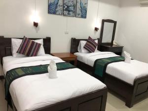 a hotel room with two beds and a mirror at Jasmine Vangvieng Hotel in Vang Vieng
