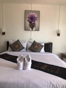 a bedroom with a bed with white shoes on it at Jasmine Vangvieng Hotel in Vang Vieng