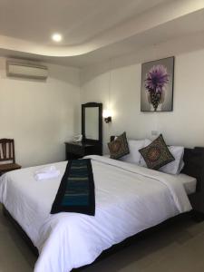 a bedroom with a large white bed with a mirror at Jasmine Vangvieng Hotel in Vang Vieng