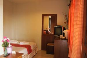 a hotel room with a bed and a television at Vacation House in Klong Muang Beach