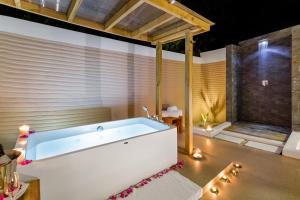 a bathroom with a large tub in a room at Kudafushi Resort & Spa in Raa Atoll