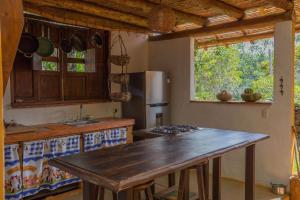 a kitchen with a wooden table and a counter top at Casa Upa ,casa con piscina espectacular, Barichara in Barichara