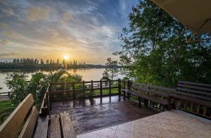 a wooden deck with benches and a view of a river at Krabi City Seaview Hotel in Krabi town