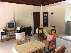 a living room with a table and chairs and a tv at Klang Dong Mountain View - Khao Yai in Klang Dong