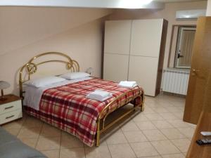 Schlafzimmer mit einem Bett mit einer roten und weißen Decke in der Unterkunft B&B Mansarda in Caserta