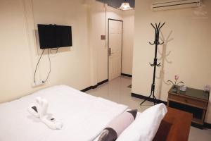 a bedroom with a white bed and a television at Khaosan Station in Bangkok