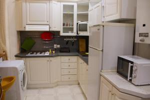 a kitchen with white cabinets and a white refrigerator at Хостел и Апартаменты Друзья in Dnipro