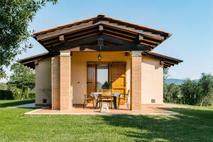 een huis met een patio met een tafel en stoelen bij Agriturismo Casa Andreina in Castiglione della Pescaia