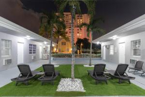 a group of chairs and palm trees in a courtyard at STYLISH 1 BEDROOM APT WITH A MASTER SUITE UNIT# 1 in Hollywood