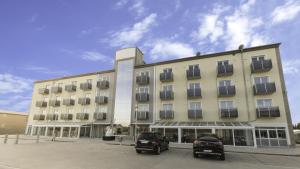 a large building with cars parked in front of it at Stadthotel Donauwörth in Donauwörth