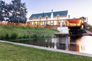 a large building with a fountain in the middle of a river at Breede River Houseboat Hire in Swellendam