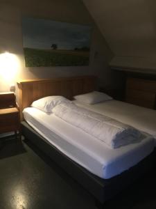 ein Bett in einem Zimmer mit einem Nachttisch und einem Bett sidx sidx in der Unterkunft Luttelkolen in Holsbeek