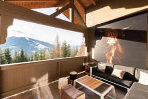 ヴァークラインにあるDesignferienhaus Luxus Bergchalet XXL Ski In-Out Snow Space Wagrain Flachauのリビングルーム(ソファ、大きな窓付)