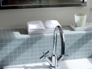 a sink with a faucet and two towels on a counter at Historisches Alpinhotel Grimsel Hospiz in Grimsel Hospiz