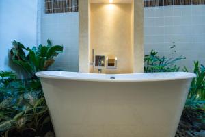 
a white bath tub sitting in the middle of a garden at Ferra Hotel and Garden Suites in Boracay
