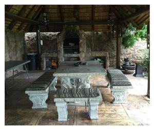 a stone patio with two benches and a table at Lala Bela Guest House in Bela-Bela