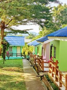 een huis met een blauw dak en een hek bij Dahla House Ranong in Ranong